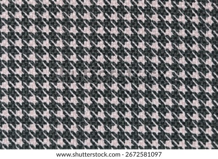 A full-frame shot of a houndstooth pattern in black and pink fabric, showcasing the woven texture and classic design.