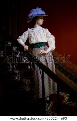 Full-lenght portrait of a young slender woman in a 1910s costume - an Edwardian hat, blouse and skirt 