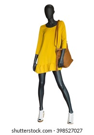 Full-length female mannequin dressed in yellow dress isolated on white background.