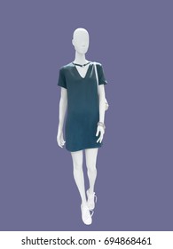 Full-length female mannequin wearing green dress, isolated. No brand names or copyright objects.