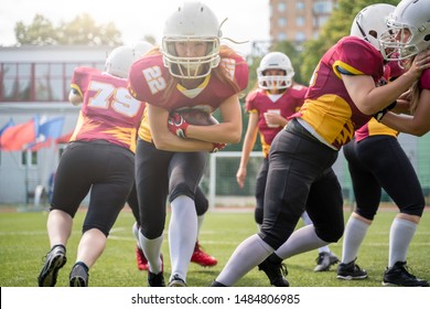 Full-length image of athletes women playing american football on green lawn on summer day - Powered by Shutterstock