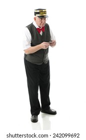 Full-length image of a senior conductor holding out his pocket watch while anxiously looking for the train.  On a white background.