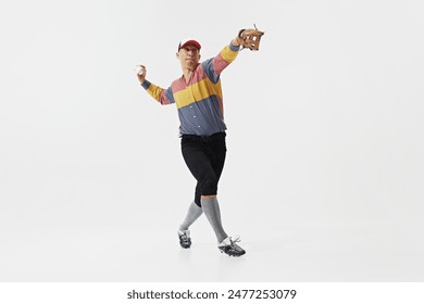 Full-length image of young guy, baseball player in serving ball, training with concentration and determination isolated on white background. Sport, retro and vintage, active lifestyle, hobby concept - Powered by Shutterstock