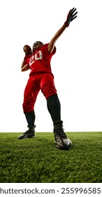 Full-length low angle view image of American football player in red uniform, competing, playing on field, throwing ball with intensity. Concept of sport, competition, tournament, game. Copy space