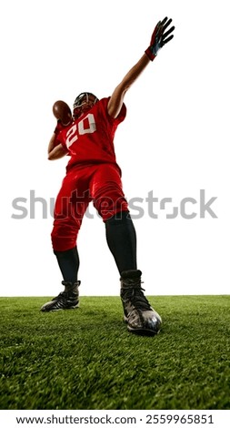 Full-length low angle view image of American football player in red uniform, competing, playing on field, throwing ball with intensity. Concept of sport, competition, tournament, game. Copy space