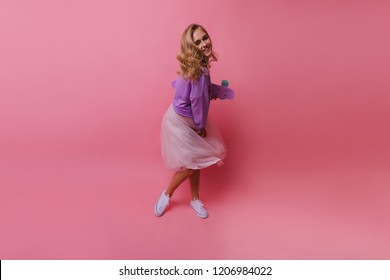 Full-length photo of graceful young lady in long white skirt. Shy female model with skateboard posing in studio. - Shutterstock ID 1206984022