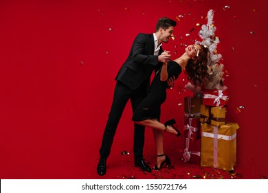 Full-length portrait of appealing woman in high heel shoes laughing in christmas night. Caucasian married couple dancing at new year party - Powered by Shutterstock