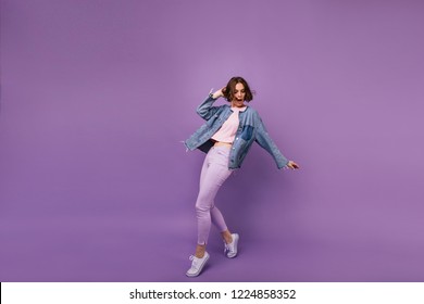 Full-length portrait of attractive slim girl wears white sport shoes. Indoor photo of enchanting caucasian woman dancing on violet background. - Powered by Shutterstock