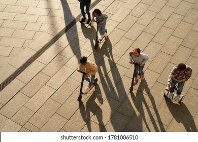 Full-length portrait of a group of millennials having fun while riding electric scooters and segways along the city. Ecological transportation, urban lifestyle concept. Horizontal shot. Top view - Powered by Shutterstock