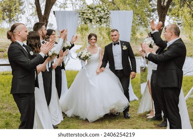 full-length portrait of the newlyweds and their friends at the wedding. The bride and groom with bridesmaids and friends of the groom are having fun and rejoicing at the wedding. - Powered by Shutterstock