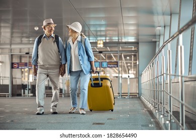 Full-length portrait of a pleased female tourist with a trolley suitcase smiling at her husband - Powered by Shutterstock