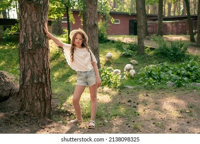 Full-length Portrait Of Tween Girl Leaning Of Tree In Courtyard Of Country House In Summer