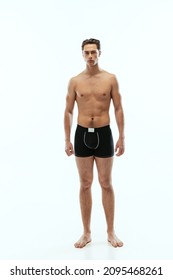 Full-length Portrait Of Young Handsome Shirtless Sportive Man Wearing Black Boxer-briefs Standing Isolated On White Background. Wellness, Wellbeing, Fitness, Sport Concept. Natural Beauty Of Male Body