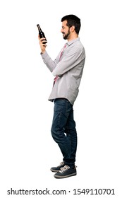 Full-length Shot Of Handsome Man With Beard Drinking Beer Over Isolated White Background