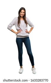 A Full-length Shot Of A Young Hispanic Brunette Woman Posing With Arms At Hip And Smiling Over Isolated White Background