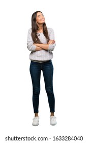 A Full-length Shot Of A Young Hispanic Brunette Woman Looking Up While Smiling Over Isolated White Background