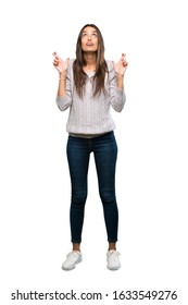 A Full-length Shot Of A Young Hispanic Brunette Woman With Fingers Crossing And Wishing The Best Over Isolated White Background