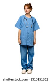 A Full-length Shot Of A Young Redhead Nurse Looking Up With Serious Face Over Isolated White Background