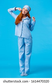 Full-length Vertical Shot Cute And Silly, Teenage Redhead Girl, Wearing Lovely Pyjama, Waking Up And Stretching, Had Good Sleep, Smiling In Morning, Standing Pleased Blue Background