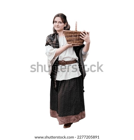 Full-length woman at the old wooden gate with a basket in her hands, isolated on a white background. Vintage clothes on Halloween style 18-19th century