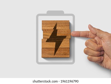 Fully charged, recharge, reboot, refresh or mindset concept. Hand putting wooden blocks with the battery charger icon on white background.
