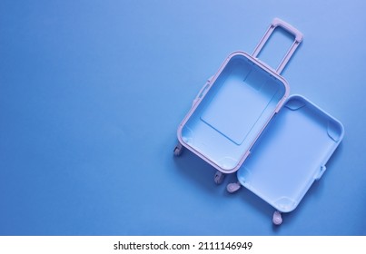 Fully opened blue suitcase, on a blue background, top view. Vacation, travel concept. copy space