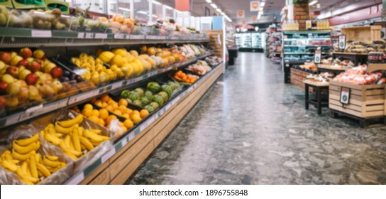 Fully stocked aisles in a grocery store. Assorted fruits and vegetables on racks in supermarket.