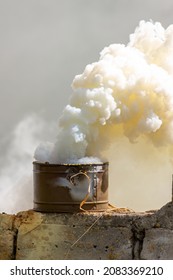 The Fuming Smoke Grenade On A Destroyed Brick Wall During Tactical Training. Used As A Signaling Device, Target Or Landing Zone Marking Device, Or As A Screening Device For Military Unit Movements