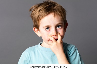 Fun 5-year Old Boy With Blue Eyes And Freckles Making An Ugly Grimace, Pulling His Eyes Down To Be A Monster, Grey Background