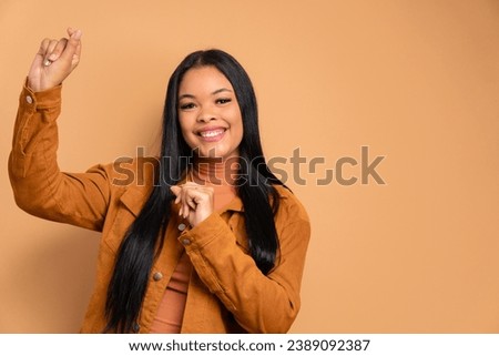 fun african american woman dancing and celebrating in beige background. celebration, positive, success concept.