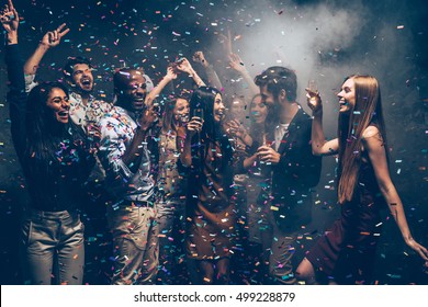 Fun And Fun Again. Group Of Beautiful Young People Throwing Colorful Confetti And Looking Happy