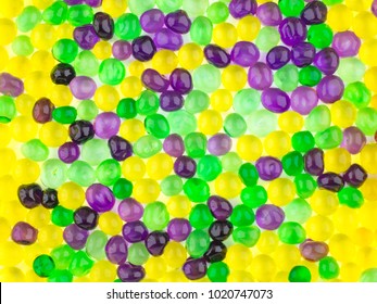 fun background: many colorful transparent beads swollen in water of the hydrogel lie side by side on a white surface - Powered by Shutterstock