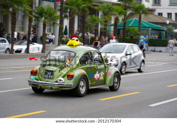 Fun classic car\
green VW Beetle decorated with cuddly toys and advertising at City\
of Lucerne on a cloudy summer day. Photo taken July 18th, 2021,\
Luzern, Switzerland.