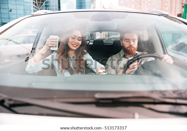 Fun couple in car. with\
coffee