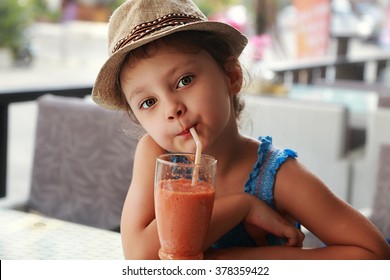 Fun Cute Kid Girl Drinking Healthy Smoothie Juice In Street Restaurant. Closeup Portrait