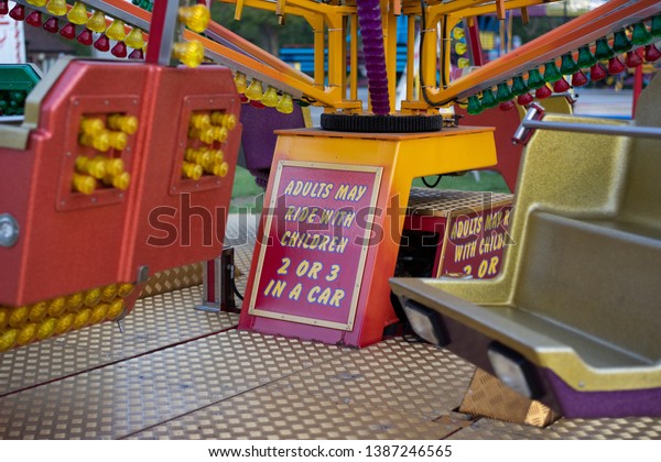 Fun\
Fair ride signs. Brightly coloured old fashioned rides not in use.\
The fair is closed and no people are present. Rides are mostly for\
young children. £2 per ride. deserted. colourful.\
