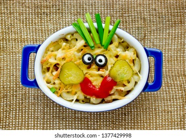 Fun Food Idea For Kids - American Mac And Cheese Macaroni Pasta Baked With Cheesy Sauce Decorated With Vegetables Like A Smiling Funny Face