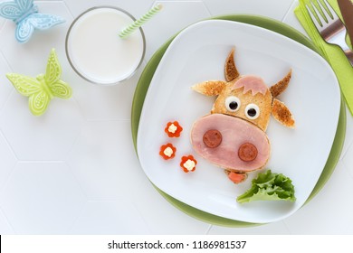 Fun Food For Kids - Cute Cow Shaped Sandwich With Ham Sausages Served With A Glass Of Milk For Breakfast Or Dinner