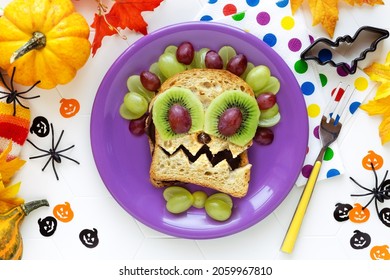 Fun Food for kids - cute Halloween monster sandwich with cholcolate spread, grapes and kiwi fruit