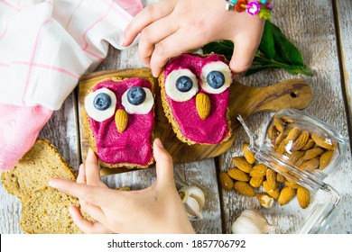 Fun food for kids - cute little owls shaped sandwiches. Spread of beets, chickpeas, almonds and garlic