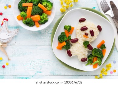 Fun food for kids - cute panda bear shaped rice with kidney beans and vegetables, carrots and broccoli. Overhead view