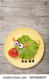 Fun Food For Kids. Funny Vegetable Pig On Yellow Plate On Vertical Wooden Background. Creative Cooking Idea.