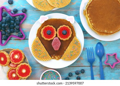 Fun Food For Kids. Owl Shape Pancake On White Plate, Blue Wooden Background, Top View. Creative Idea For Kids Breakfast