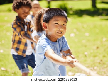 Fun, games and children playing tug of war together outdoor in a park or playground during summer. Friends, diversity and kids pulling a rope while having fun or bonding in a garden on a sunny day - Powered by Shutterstock