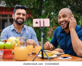 Fun Gay Couple Sitting And Using Mobile For Video Call In Table Outside