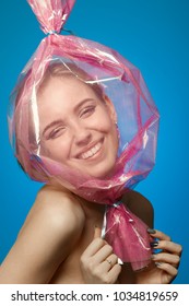 Fun Girl With Head Inside Candy Wrapper On Blue Background