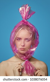 Fun Girl With Head Inside Candy Wrapper On Blue Background