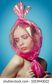 Fun Girl With Head Inside Candy Wrapper On Blue Background