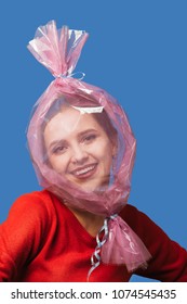 Fun Girl With Head Inside Candy Wrapper On Blue Background