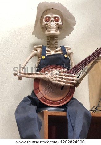 fun Halloween decoration - skeleton wearing overalls and playing the banjo